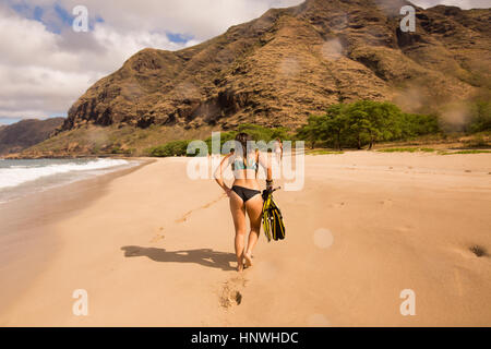 Rückansicht der Trägerin Bikini zu Fuß am Strand, Oahu, Hawaii, USA Stockfoto