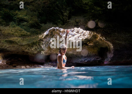Frau im Wasser gefüllte Höhle Blick in die Kamera, Oahu, Hawaii, USA Stockfoto