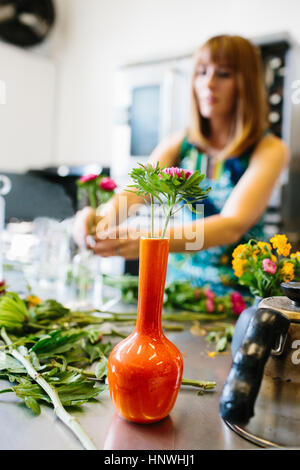 Frau, die Vermittlung von Blumen in vase Stockfoto