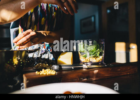 Frau, die Zubereitung von Pasta mit Basilikum, Pinienkernen Stockfoto