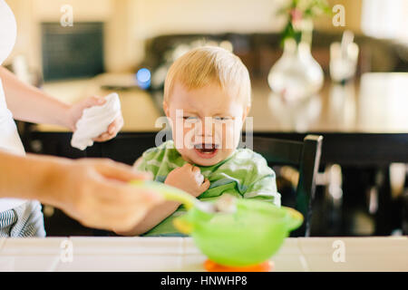 Mutter hilft Sohn Sohn weint, frühstücken Innenfeldes Stockfoto