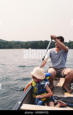 Junger Mann und Tochter über See im Ruderboot Rudern Stockfoto