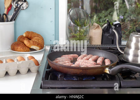 Frühstück Würstchen braten in der Pfanne auf dem Kochfeld Stockfoto