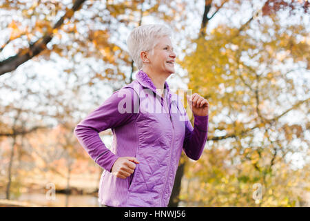 Ältere Frau ausüben, laufen, in ländlicher Umgebung Stockfoto