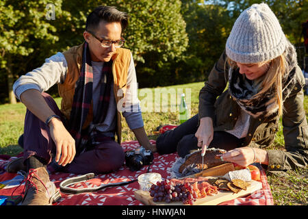 Paar, die Zubereitung der frischen Picknick auf Schneidebrett im park Stockfoto