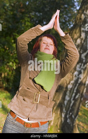 Model Release, Junge Frau Macht Jogauebung Im Herbstlichen Park - junge Frau macht Yoga im Herbst Natur Stockfoto