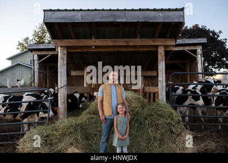 Porträt von Vater und Tochter neben Kuhstall Stockfoto