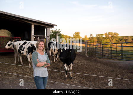 Porträt von Bäuerin auf Bauernhof, Kühe im Hintergrund Stockfoto