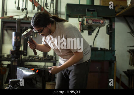 Männlichen Schmied Hämmern rote Roheisen auf Workshop-Amboss Stockfoto