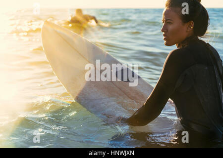 Junge Surferin waten im Meer, Newport Beach, Kalifornien, USA Stockfoto