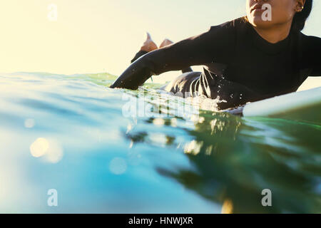 Junge weibliche Surfer paddeln Surfbrett auf hoher See, Newport Beach, Kalifornien, USA Stockfoto