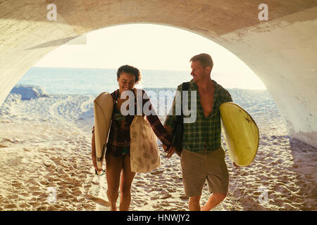 Surfen-paar zu Fuß in Unterführung in Newport Beach, Kalifornien, USA Stockfoto