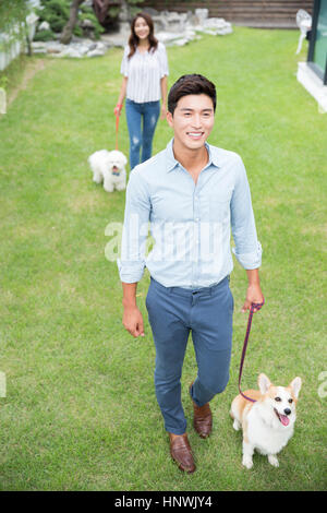 Junge Paar zu Fuß lächelnd Haustier Hunde Stockfoto