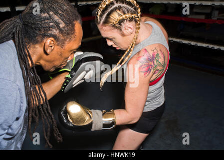 Boxerin Stanzen des Trainers Boxen Mitt im Boxring Stockfoto