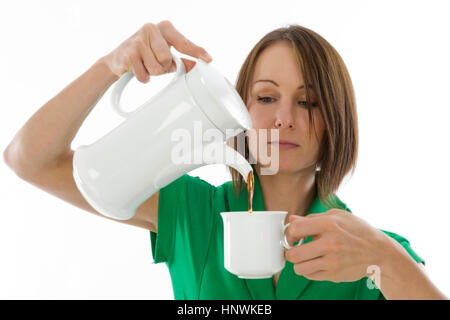 Model Release, Junge Frau Schenkt Kaffee in Kaffeetasse - Frau mit Kaffeetasse Stockfoto