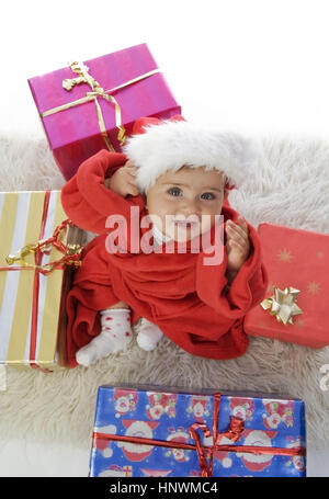 Model Release, Kleinkind, 1 Jahr, Im Weihnachtsmannkostuem Mit Geschenken - kleines Mädchen verkleidet als Weihnachtsmann Stockfoto