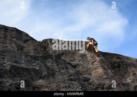 Kletterer oben aufsteigend. Erfolgreich auf natürliche Felswand klettern. Extreme Sport-klettern. Stockfoto