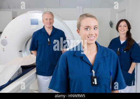 Lächelnd medizinischer Fachmann mit Kollegen von MRI Mac stehend Stockfoto