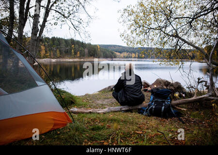 Männliche Wanderer genießen den Blick auf den See am Campingplatz Stockfoto