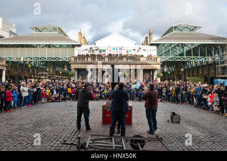 Covent Garden: Ein Entertainer für riesige Menschenmengen in Londons berühmten Covent Garden Markt durchführt. Stockfoto