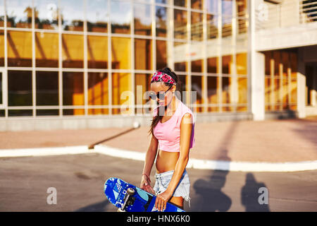 Junge Frau im Freien, halten skateboard Stockfoto