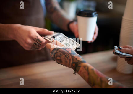 Kunden, die ihren Kaffee mit Bargeld bezahlen Stockfoto