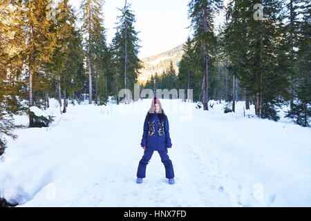 Porträt der Frau im stricken Hut und Winterkleidung im verschneiten Wald, Österreich Stockfoto