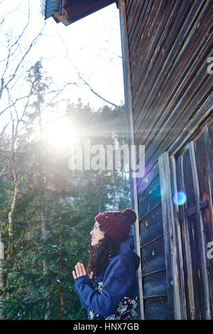 Frau in Strick Mütze praktizieren Yoga, meditieren von Blockhaus Stockfoto