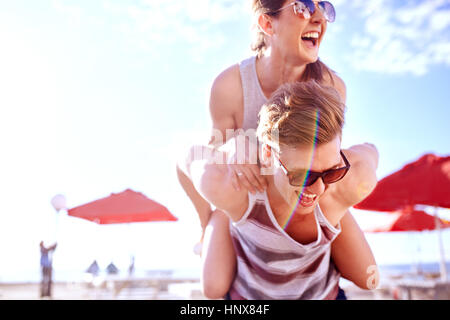 Mann mit lächelnden Frau Huckepack Stockfoto