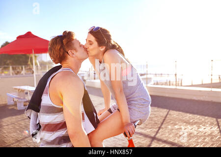 Paar auf Promenade auf Fahrrädern küssen Stockfoto