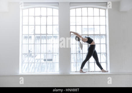 Frau steht auf dem Fensterbrett biegen nach hinten Strecken Stockfoto