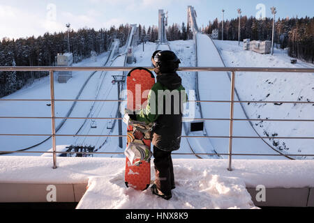 Rückansicht eines jungen mit Snowboard auf der Piste Stockfoto