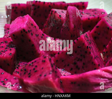 Rosa Pitaya Frucht, auch bekannt als Drachenfrucht in Scheiben schneiden. Obst mit der schuppigen Exterieur und Interieur saftig, Rosa mit schwarzen Samen. Stockfoto