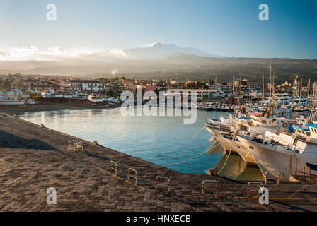 Der Hafen von Riposto während des Sonnenuntergangs; schneebedeckten Vulkan Ätna im Hintergrund Stockfoto