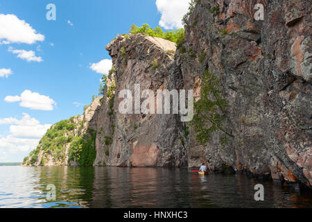 Man paddelt eine Kanu entlang der Felsen auf dem Bon Echo Lake in Ontario Stockfoto