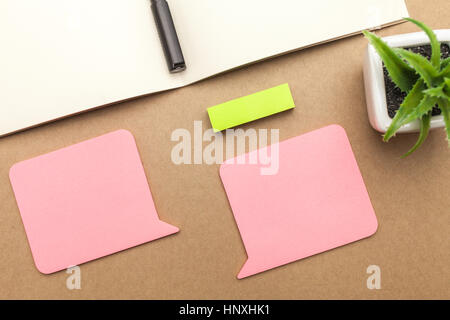 Leeres Papier, Buch, Stift und Pflanze auf braunem Hintergrund Stockfoto