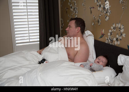 Betonte müde Papa Baby niederlassen wollen Stockfoto