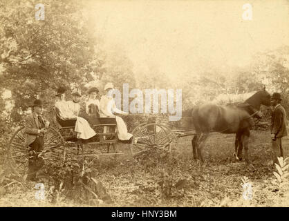 Antike c1890 Foto, Gruppe der viktorianischen Frauen in einer Kutsche mit afrikanisch-amerikanischer Mann Zügel. Ort: New England, USA. QUELLE: ORIGINAL FOTOABZUG. Stockfoto