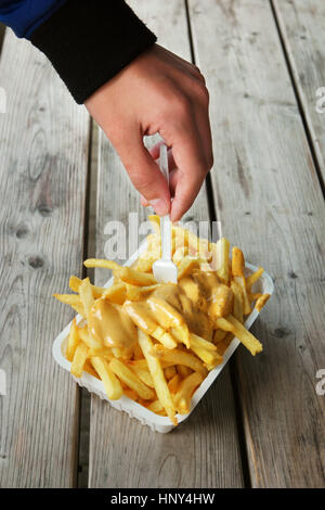 Belgische Pommes Frites. Hände mit einem Tablett frisch gebackene belgische Pommes Frites und Soße obendrauf. Stockfoto
