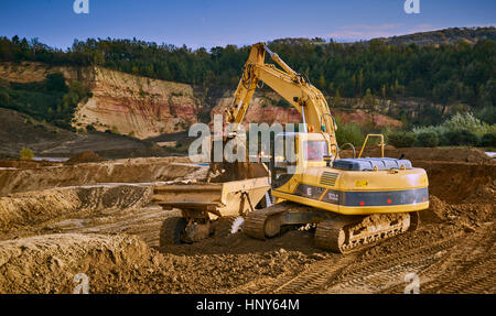 Gewinnung von Sand mit einem Bagger und Kipper in einem Steinbruch Stockfoto