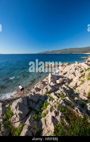 Junge Frau, die Ausübung von Sunrise am Stein Strand in Kroatien, Europa Stockfoto