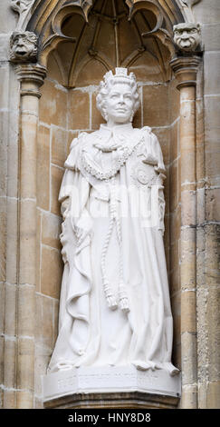 Statue von Königin Elizabeth II auf einer Außenwand an die Kathedrale von Canterbury, England. Stockfoto