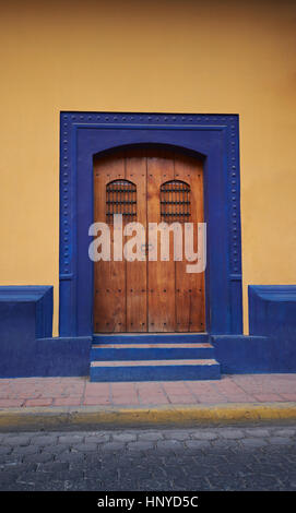 Holztür im gelben Haus Blick von der Straße. Antike Holztür Stockfoto