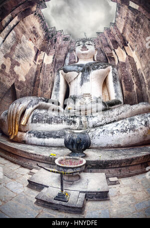 Riesige Buddha-Statue Phra Achana in Wat Si Chum in grau bedecktem Himmel in Sukhothai Historical Park, Thailand anrufen Stockfoto