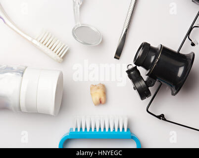 Extrahierte Zähne um zahnärztliche Instrumente isoliert auf weißem Hintergrund Stockfoto