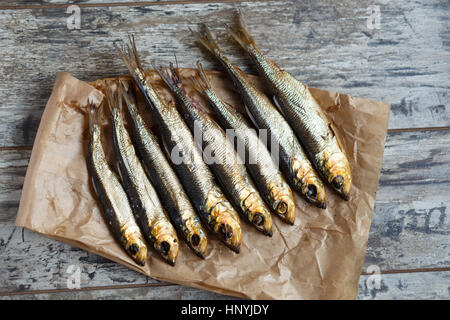 geräucherter Hering auf ein Papier und Holztisch. Stockfoto