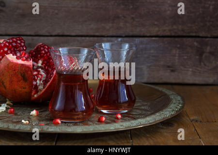 Eine Brille von Granatapfelsaft mit frischem Granatapfel Früchte auf Holztisch. Vitamine und Mineralstoffe. Gesundes Getränk Konzept. Stockfoto