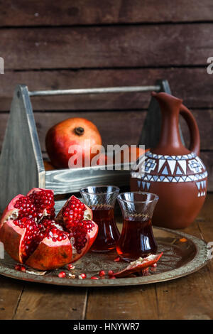 Reifen Granatapfelfrucht auf Holz Vintage-Hintergrund. Roten Saft Granatapfel auf dunklem Hintergrund. Frische saftige Granatapfel - ganze und geschnittene, Ansicht von oben. Saftige Granatäpfel auf Holz Stockfoto