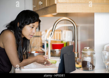 Frau mit digital-Tablette während der Zubereitung von Speisen zu Hause Stockfoto