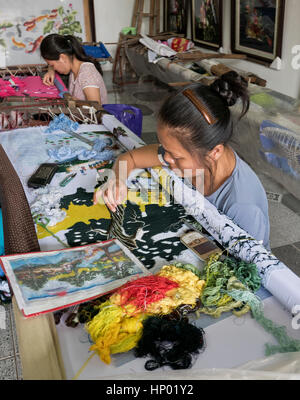 Frau Hand Sticken bunten vietnamesischen Szene, Hanoi Industrie Dorf Quat Dong. Stockfoto